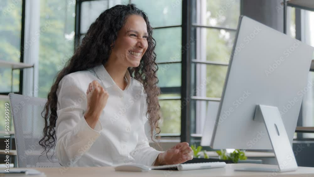 Young hispanic woman office manager typing on computer happy excited female wins online lottery rejoices at achievement celebrating success victory achieves goal reading good news gets new opportunity Young hispanic woman office manager typing on computer happy excited female wins online lottery rejoices at achievement celebrating success victory achieves goal reading good news gets new opportunity