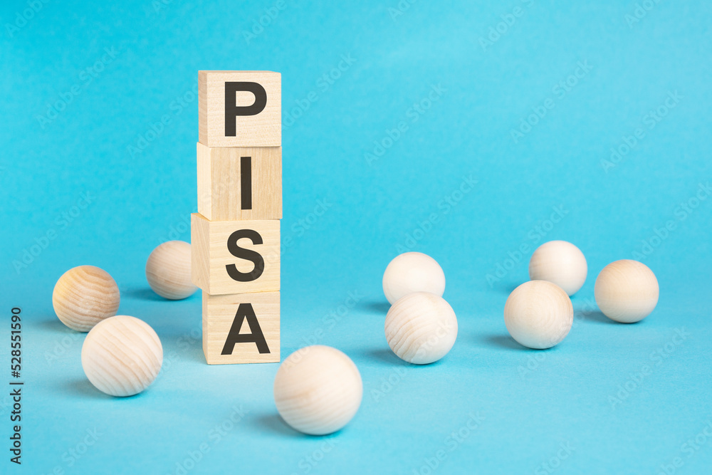 pyramid of wooden cubes with the word PISA and wooden balls on a blue background pyramid of wooden cubes with the word PISA and wooden balls on a blue background