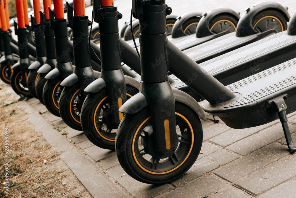 Electric scooter. Ecological transport. Many electric scooters stand in the parking lot