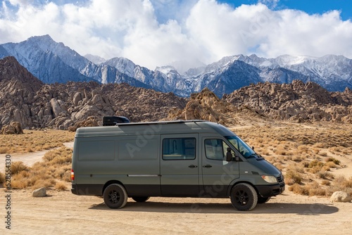off road sprinter van in front of a snow covered mountain range in the sierra nevadas vanlife