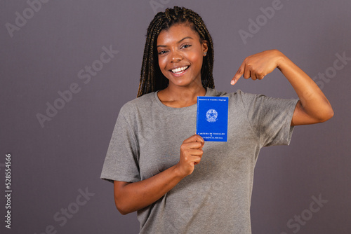 Young afro brazilian woman holding work card and social security. Official document, Human resources, labor market. photo