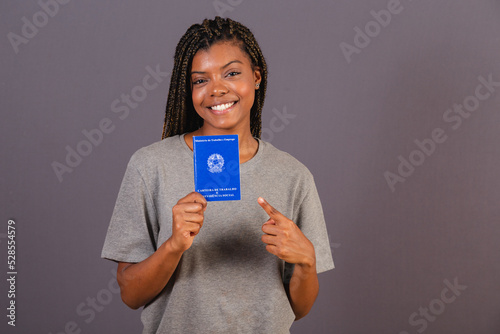 Young afro brazilian woman holding work card and social security. Official document, Human resources, labor market. photo