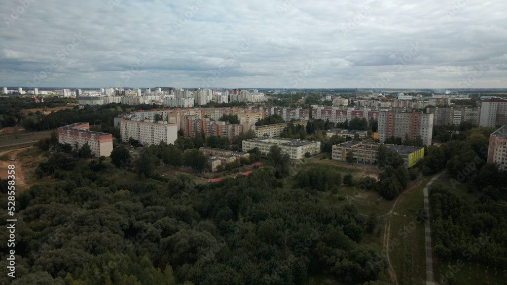 Obraz premium City with high-rise buildings. Park area in the foreground. Blue sky with clouds. Aerial photography.