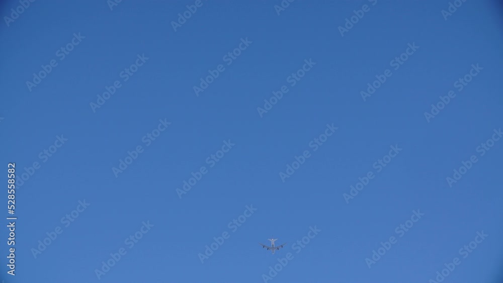 Lockdown Low Angle View Of Airplane Flying In Sky On Sunny Day - Santa Monica, California Lockdown Low Angle View Of Airplane Flying In Sky On Sunny Day - Santa Monica, California