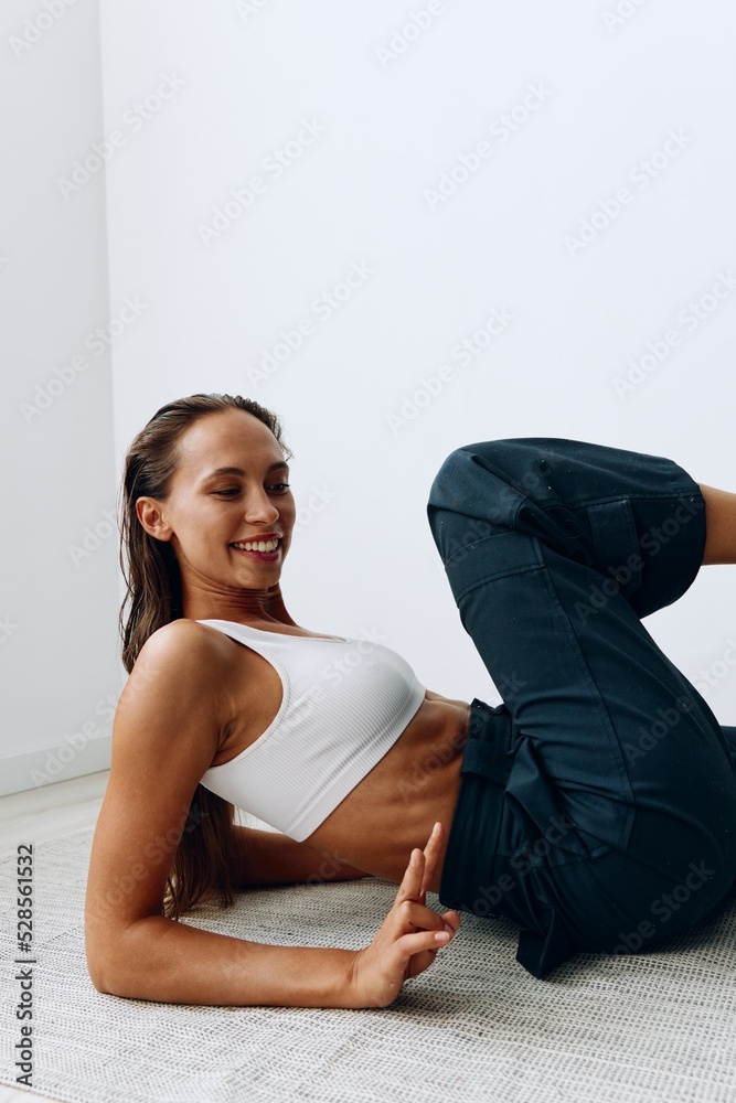 A woman goes in for sports on the floor with an online trainer through a laptop. Sports in lockdown A woman goes in for sports on the floor with an online trainer through a laptop. Sports in lockdown