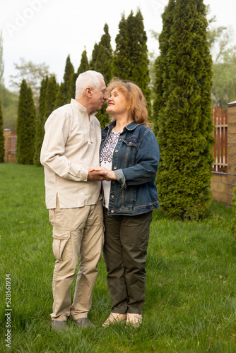 Senior elder caucasian couple together in park in autumn or summer. Wife hugging husband smile with happiness. Beautiful love relation and care of retirement old people. © Marharyta