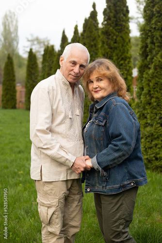 mature senior couple hugging outside in autumn or summer nature in park