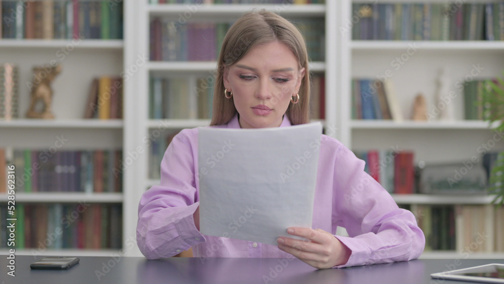 Woman Reading Reports while Sitting in Office Woman Reading Reports while Sitting in Office