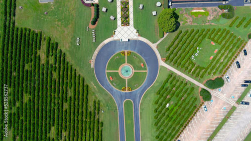 aerial shot of a circular driveway with a water fountain in the center at a vineyard surrounded by lush green trees, grass and plants at Chateau Elan Winery & Resort in Braselton Georgia USA