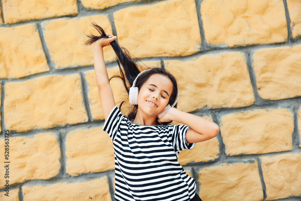 Have a nice time. A child with headphones listening to music. Audiobook concept. Learning audio lessons. a little girl with headphones listening to music Have a nice time. A child with headphones listening to music. Audiobook concept. Learning audio lessons. a little girl with headphones listening to music