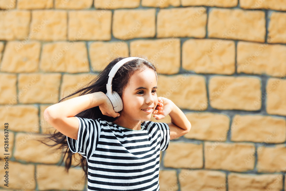 Have a nice time. A child with headphones listening to music. Audiobook concept. Learning audio lessons. a little girl with headphones listening to music
