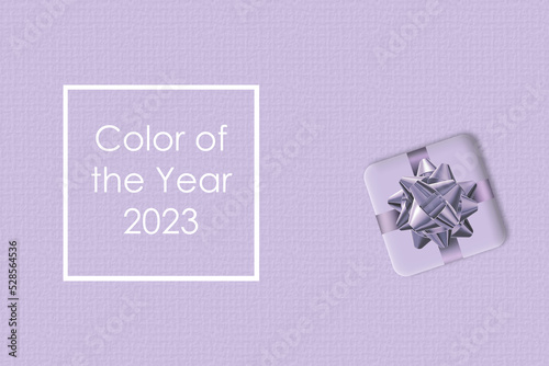 Digital Lavender Color of the Year 2023, New Year gift with bow on lavender background. In the trend color lavender blue. Top view, Flat lay, copy space. Text Color of the year. Creative illustration