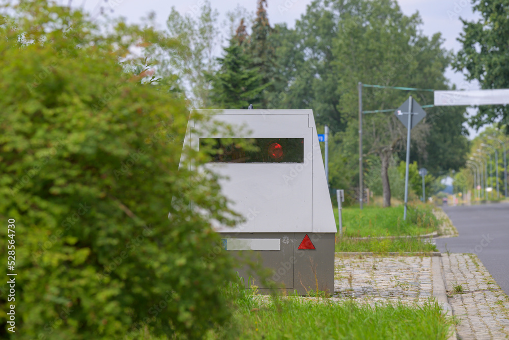 Ein Blitzeranhänger durch ein Gebüsch getarnt