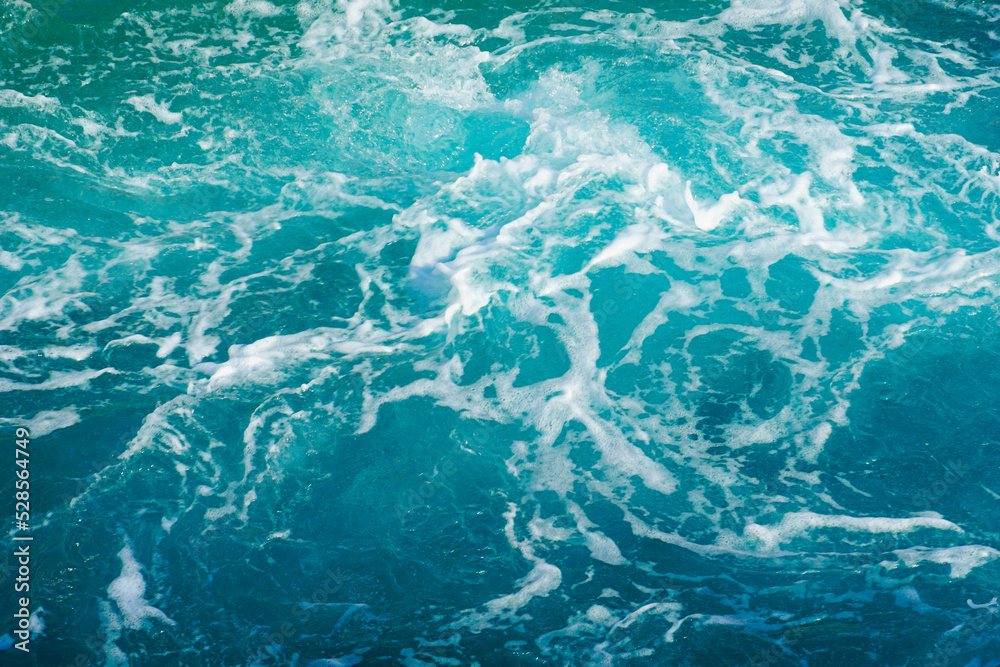 Turquoise abstract of sea surface with turbulent foamy water