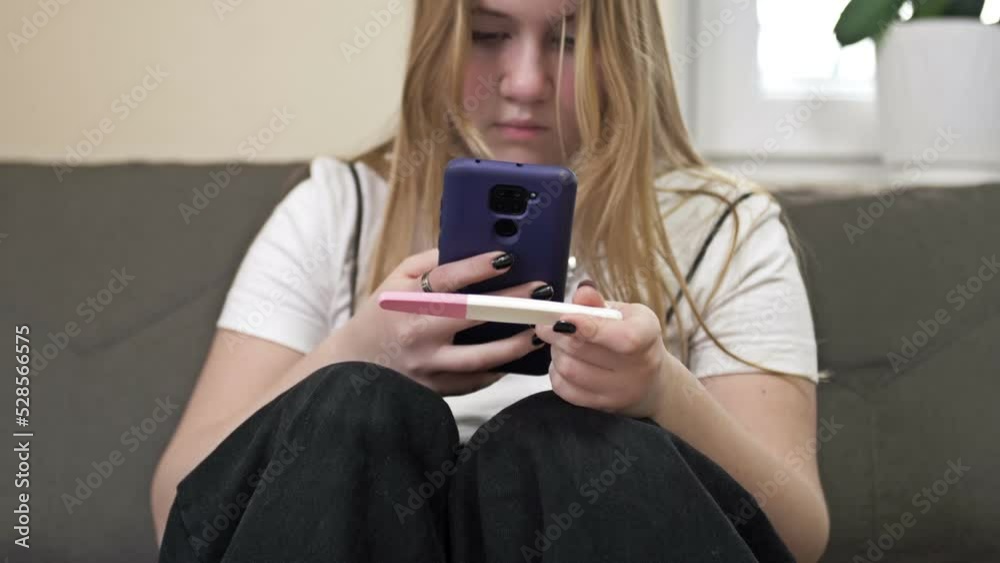 Teenage girl looks at the result of a pregnancy test and cries. The social problem. Teenage girl looks at the result of a pregnancy test and cries. The social problem.
