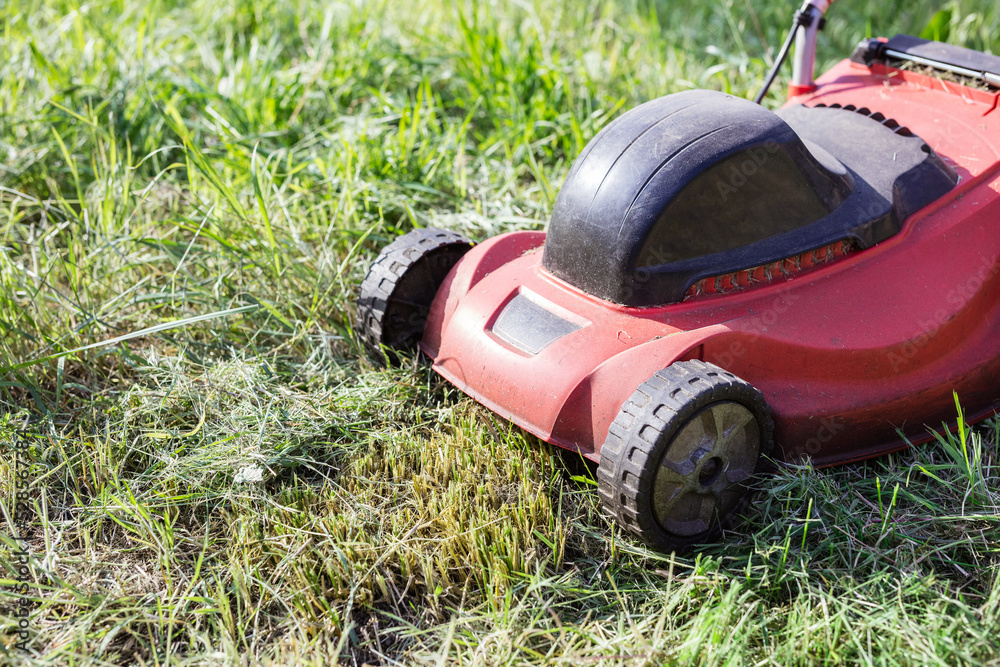 Lawnmower on green grass in the garden Lawnmower on green grass in the garden