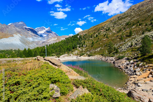 View of Grunsee lake (Green Lake) and the Swiss Alps at summer on the Five Lakes Trail in Zermatt, Switzerland photo