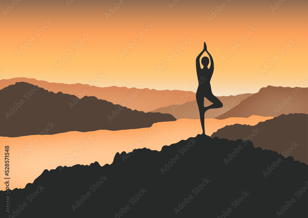 A woman in yoga tree pose in the mountain at sunrise.