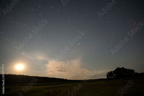 Beautiful panorama of bright blue sky with shining stars and milkyway over dark mountains landscape at night