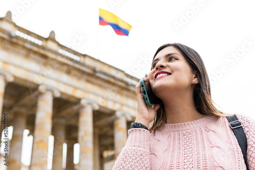 girl talking on the cell phone with a colombian flag in the background