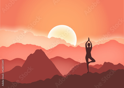 Yoga woman standing in tree pose in mountains at beautiful sunrise.