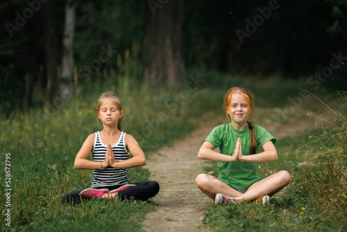 Two girls girlfriends meditate in the park.
