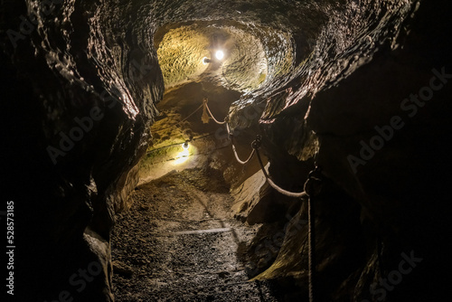 Photographie Interior of an underground cavern illuminated by spotlights.
