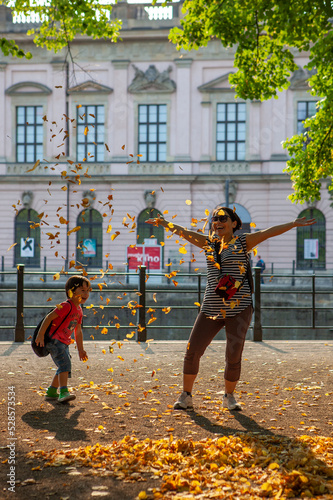 mujer y niño jugando con hojas 
