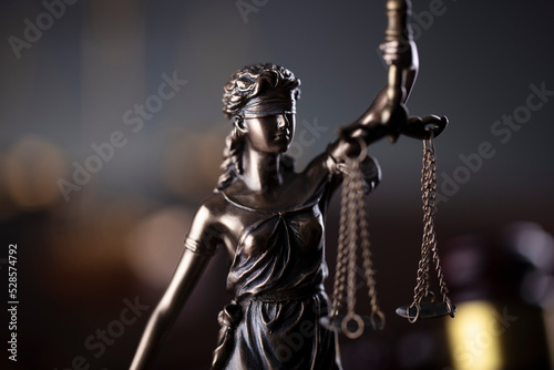 Law symbols composition. Law and justice concept. Themis sculpture and judge’s gavel on gray background.
