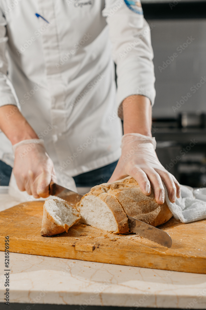 Male chef's hands cut bread Male chef's hands cut bread