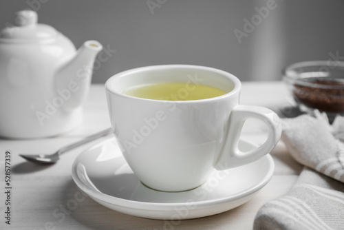 Cup of buckwheat tea on white wooden table