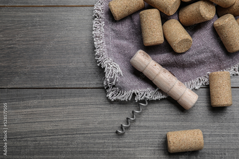 Corkscrew and wine bottle stoppers with napkin on wooden table, flat lay. Space for text Corkscrew and wine bottle stoppers with napkin on wooden table, flat lay. Space for text