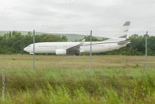 a large white passenger plane is picking up speed at the airfield to take off against the background of green grass. Civil air transport. A big plane on the runway.