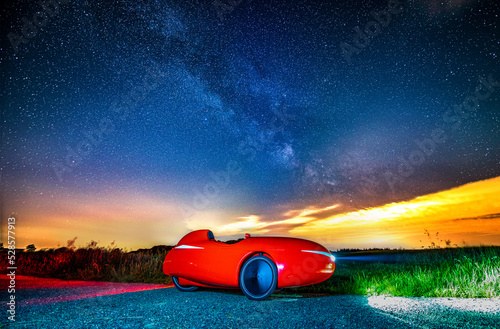 A red velomobile (recumbent tricycle /Human Powered Vehicle) on a clear summernight on a lonely road under the milky way. On the horizon clouds and the airpollution reflect the city lights.  photo