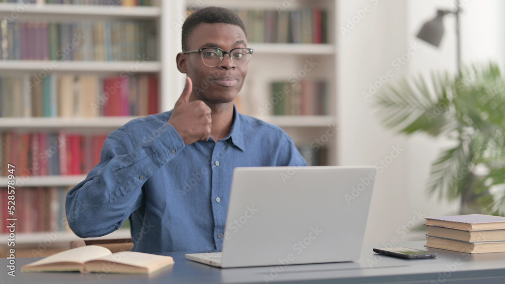Young African Man Showing Thumbs Up While using Laptop Young African Man Showing Thumbs Up While using Laptop