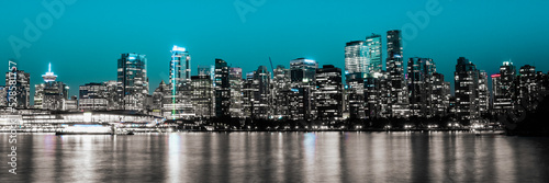 Vancouver city skyline at night with seawater reflections in Vancouver Harbor  British Columbia  Canada. Monochromatic nightscape of metropolitan downtown buildings.