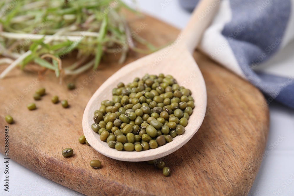 Wooden spoon with mung beans and board on table, closeup Wooden spoon with mung beans and board on table, closeup