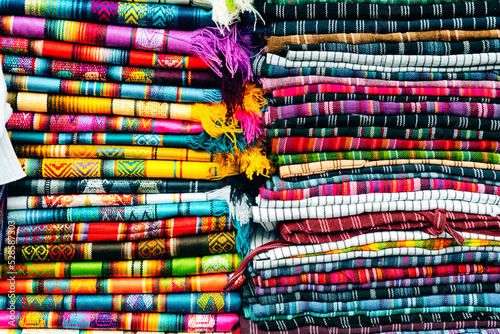 colorful scarfs pile at ecuadorian handcraft market photo