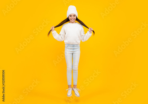 Fototapeta Naklejka Na Ścianę i Meble -  Excited face. Amazed expression, cheerful and glad. Happiness, freedom, motion and child. Young teenager girl wear summer dress jumping in air.