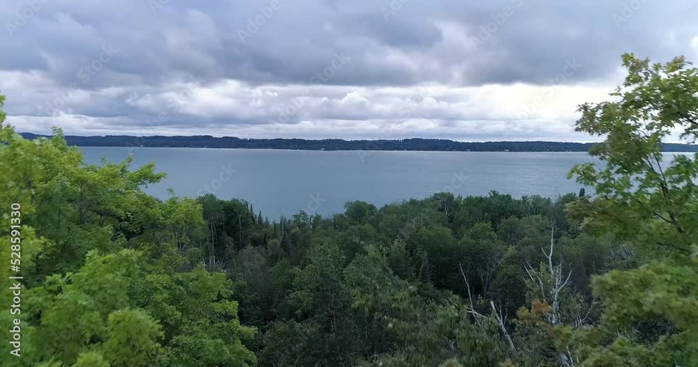 Aerial drone view of Torch lake revealing through tree tops. Aerial drone view of Torch lake revealing through tree tops.