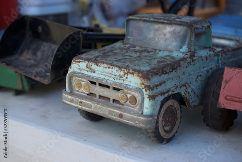 An old rusty truck is actually an antique for sale at this flea market in Upstate NY.  Well worn blue toy truck on display and for sale. photo