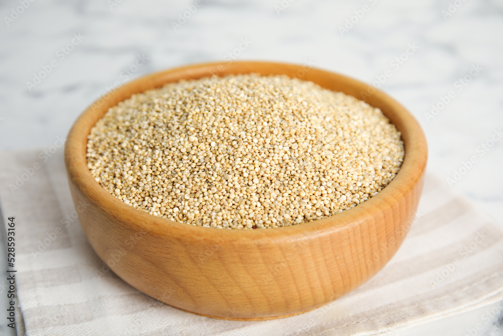 Wooden bowl with white quinoa on table, closeup Wooden bowl with white quinoa on table, closeup