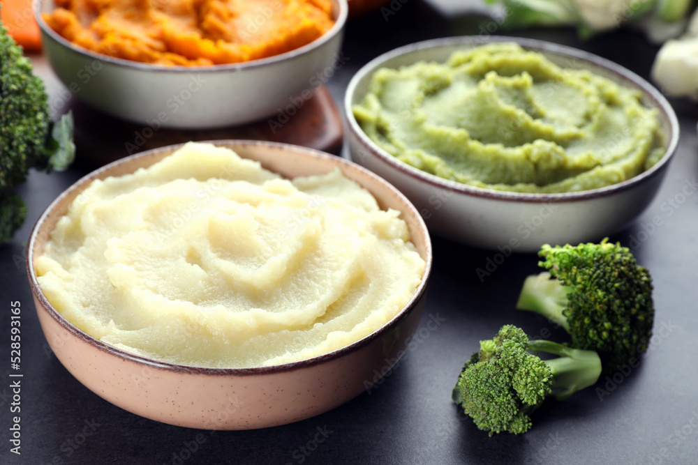 Bowls with tasty different puree and ingredients on black table, closeup Bowls with tasty different puree and ingredients on black table, closeup