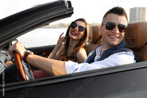 Stylish couple driving luxury convertible car outdoors © New Africa