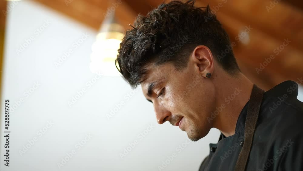 focused caucasian young chef in the kitchen preparing food. healthy lifestyle. Concept of craftsmanship, small business, skilled professional millennial. focused caucasian young chef in the kitchen preparing food. healthy lifestyle. Concept of craftsmanship, small business, skilled professional millennial.