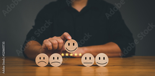 customer services best excellent business rating experience. Satisfaction survey concept. Hand of a businessman chooses a smile face on wood block circle. 5 Star Satisfaction... photo