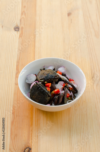 Obraz na płótnie Small black crab sour salad on wooden background, Thai traditional food w salonie