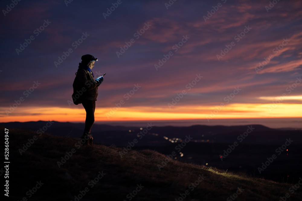 Mid Adult Woman Using For Navigation a Mobile Phone From A Remote location High Above a Valley Mid Adult Woman Using For Navigation a Mobile Phone From A Remote location High Above a Valley