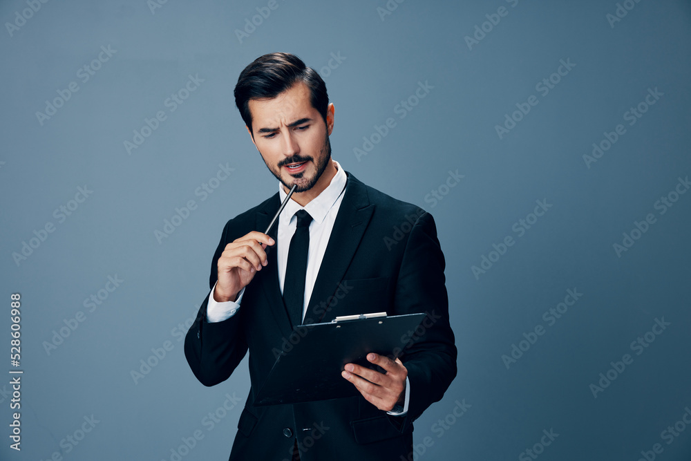 An angry business man with a headache is holding a folder of notes in his hands with a pen screaming into the camera. Business and technology in copy space management An angry business man with a headache is holding a folder of notes in his hands with a pen screaming into the camera. Business and technology in copy space management