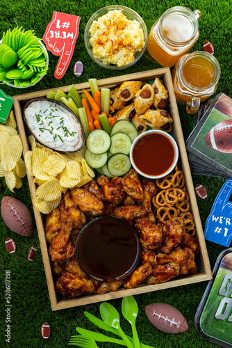 Football game day tail gate party tray filled with snack , beer and finger foods close up.